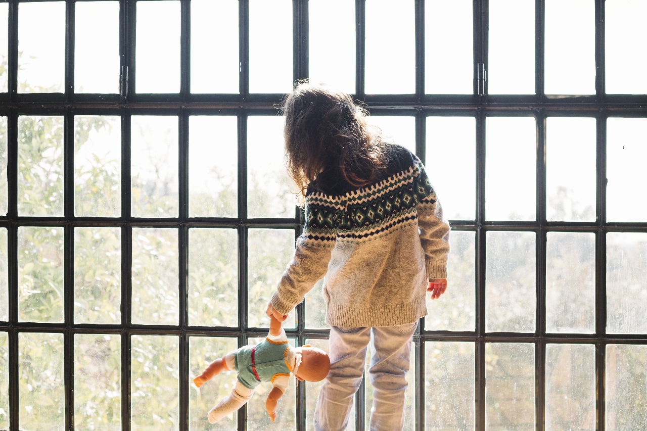 Niña de espaldas sosteniendo una muñeca, imagen utilizada para el llamado a concurso Abriendo Caminos de CATIM.